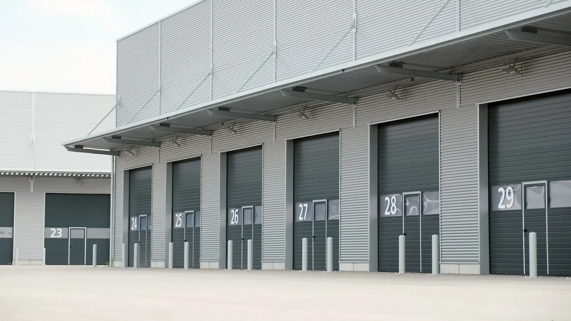 Row of numbered sectional overhead doors at an industrial loading dock